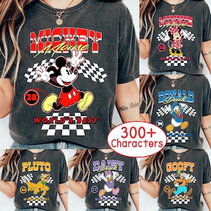 May include: A collection of dark gray t-shirts featuring Disney characters. Each shirt has a character graphic, a checkered flag design, and the words "WORLD'S BEST". Characters include Mickey Mouse, Minnie Mouse, Donald Duck, Pluto, Daisy Duck, and Goofy.