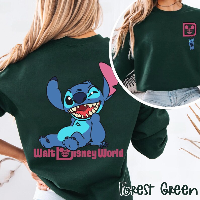 May include: Forest green sweatshirt featuring a smiling blue cartoon character with large ears and a wide grin. The back of the sweatshirt displays the character and the words "Walt Disney World". A smaller graphic is on the upper chest.