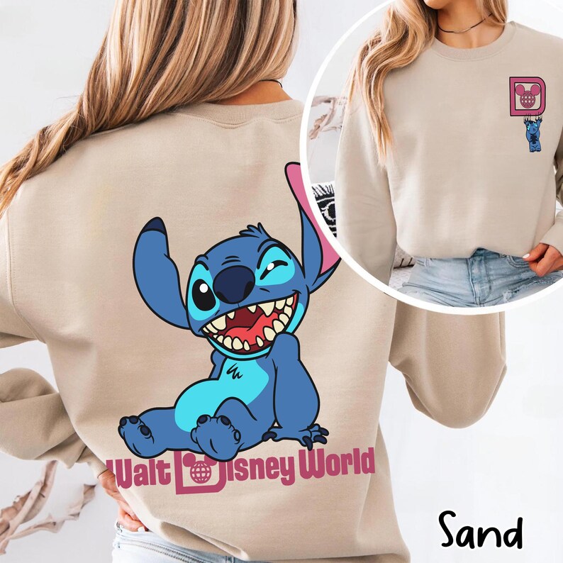 May include: Sand-colored sweatshirt featuring a blue Stitch graphic on the back and a smaller Stitch design on the front. The back graphic includes the text "Walt Disney World". The sweatshirt is a neutral color.
