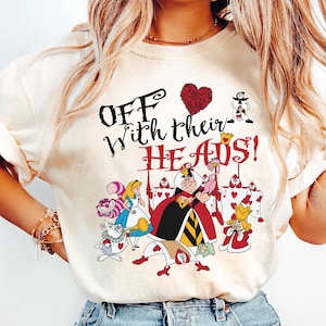 May include: A white t-shirt with a graphic print of characters from Alice in Wonderland. The text on the shirt reads "Off with their heads!"