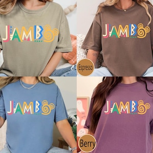 Puede incluir: Cinco camisetas de diferentes colores con la palabra "JAMBO" impresa en letras de colores en la parte delantera. Los colores son caqui, espresso, azul vaquero, baya y blanco.