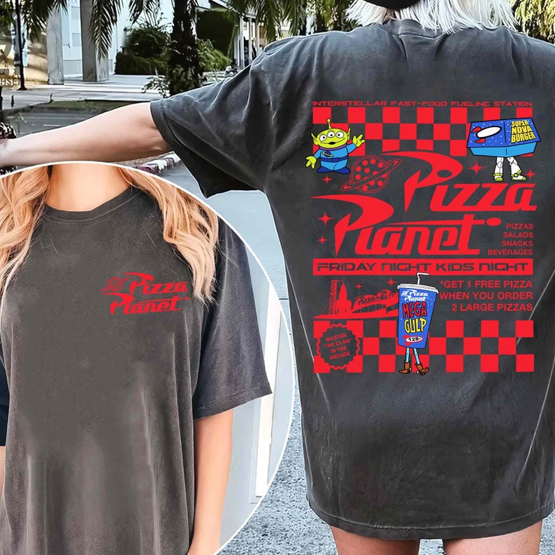Op de afbeelding: Een zwart T-shirt met een rood-wit geruit patroon en een afbeelding van het Pizza Planet restaurant uit de Toy Story film. De afbeelding bevat de tekst "Pizza Planet", "Interstellar Fast-Food Fueling Station", "Friday Night Kids Night", en "Get 1 Free Pizza When You Order 2 Large Pizzas".
