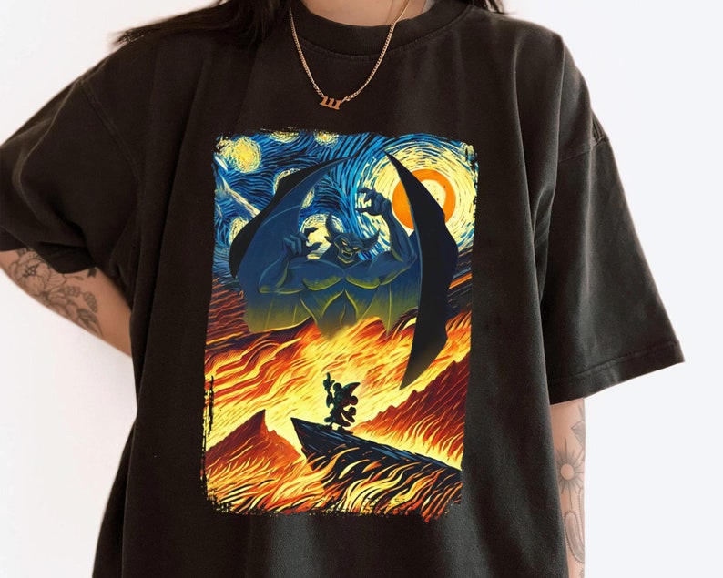 May include: Black t-shirt with a graphic print of a cartoon demon with wings, standing in a fiery landscape inspired by Vincent van Gogh's Starry Night.
