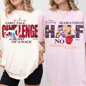 May include: Two t-shirts, one cream and one pink, featuring Disney Princess designs. The cream shirt has "Fairy Tale Challenge" text and a Belle graphic. The pink shirt says "Marathon Half" with a Rapunzel graphic and "No Shortcuts".