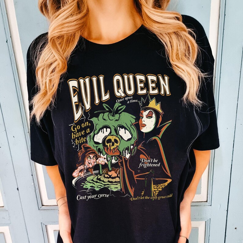 May include: Black t-shirt with a graphic print of the Evil Queen from Snow White. The graphic features the Evil Queen holding a poisoned apple, with the text "Evil Queen", "Go on, have a bite", "Cast your curse", "Don't be frightened", and "Don't let the wish grow cold".