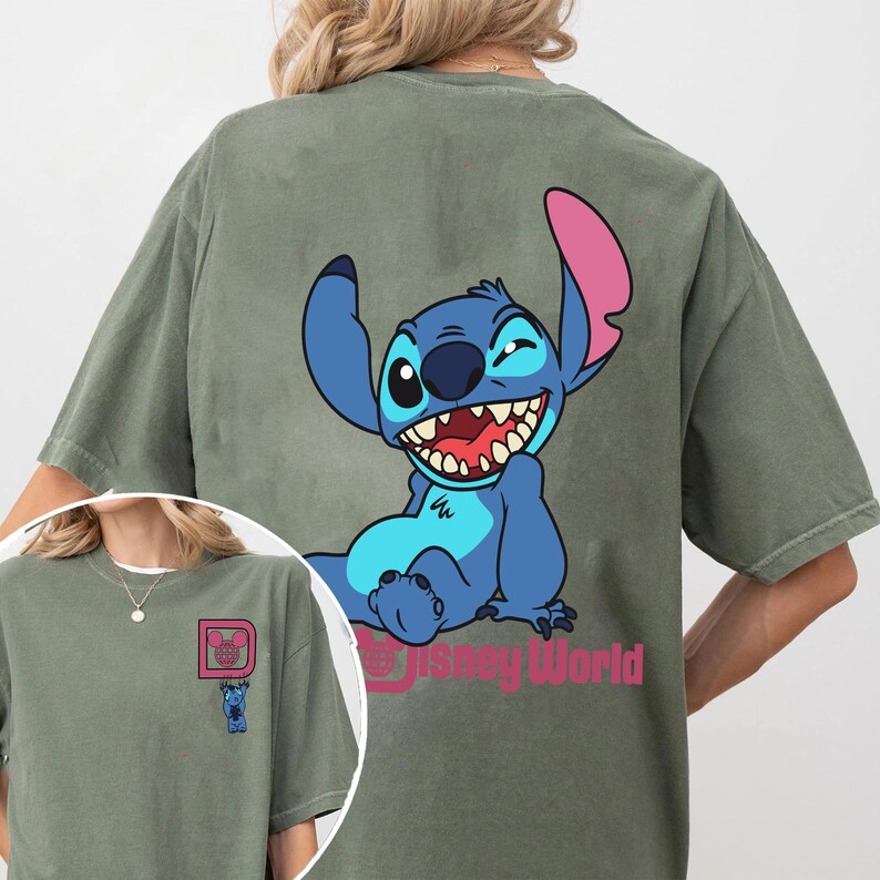May include: Olive green t-shirt featuring a large graphic of the character Stitch from Disney's Lilo & Stitch. Stitch is blue with pink ears and is winking. The text "Disney World" is below the graphic.