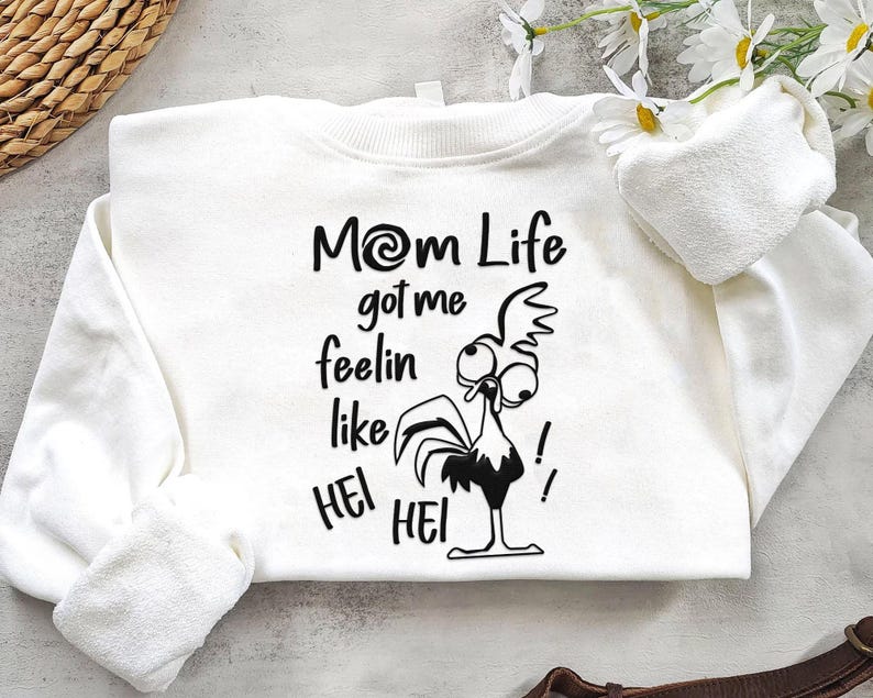 May include: White sweatshirt with a black and white illustration of a rooster with the text "Mom Life got me feelin like Hei Hei!"