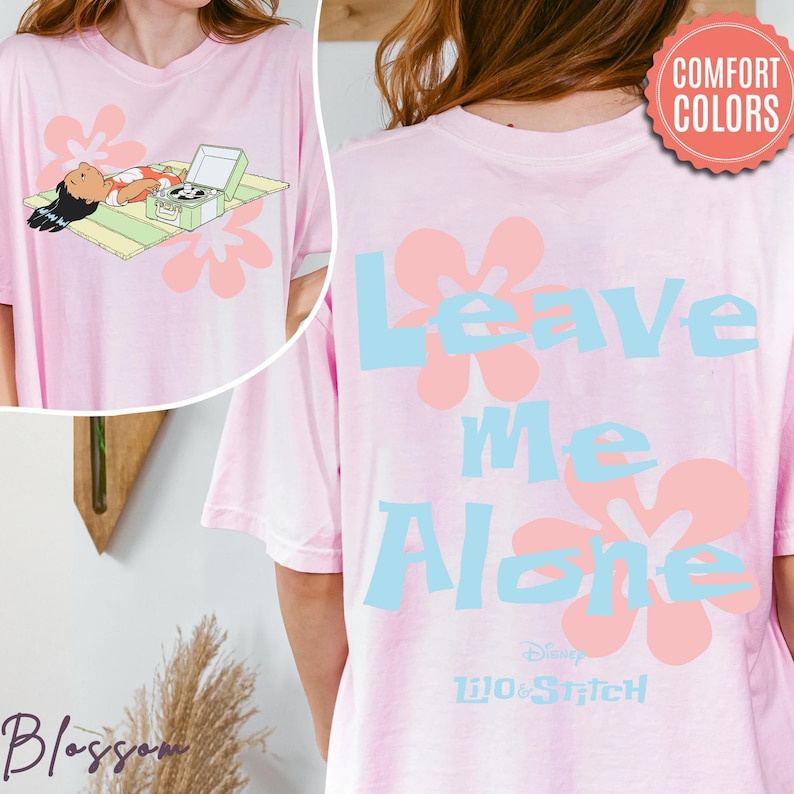 Puede incluir: Camiseta rosa claro con un gr&aacute;fico de un personaje y un tocadiscos, y el texto "Leave Me Alone" con acentos florales. La camiseta es de Lilo & Stitch de Disney.