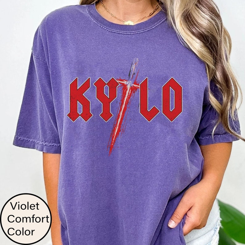 May include: Purple t-shirt featuring a red graphic of a lightsaber and the word "KYLO" in a bold, red font.