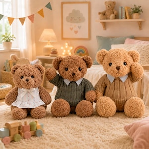 May include: Three plush teddy bears sitting on a rug. The left bear wears a white floral dress with a bow. The middle bear wears a dark green ribbed sweater with a light blue collar. The right bear wears a tan ribbed sweater with a light blue collar.