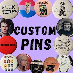 May include: A collection of custom pins with various designs and text. The pins feature images of a cat, band logos, portraits, and phrases like "FUCK TERFS" and "NOT GAY AS IN HAPPY, BUT QUEER AS IN ROCK YOU". The word "CUSTOM PINS" is in the center.