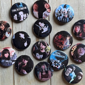 May include: A collection of round pinback buttons featuring images of actors and scenes from the Final Destination movie franchise. The buttons have various designs, including movie stills and text.