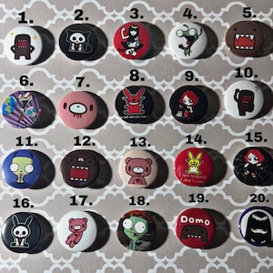 May include: Twenty colorful round buttons with various cartoon characters and designs. The buttons are numbered 1 through 20.