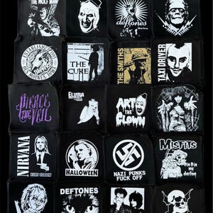 May include: A collection of black square patches featuring white graphic designs and text. The patches showcase various themes, including band logos like "Nirvana" and "Misfits", horror movie characters, and other pop culture references. The patches are arranged closely together.