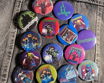 May include: A collection of 14 round, colourful buttons featuring various Goosebumps book covers. The buttons depict illustrations of monsters, spooky scenes, and the Goosebumps logo.