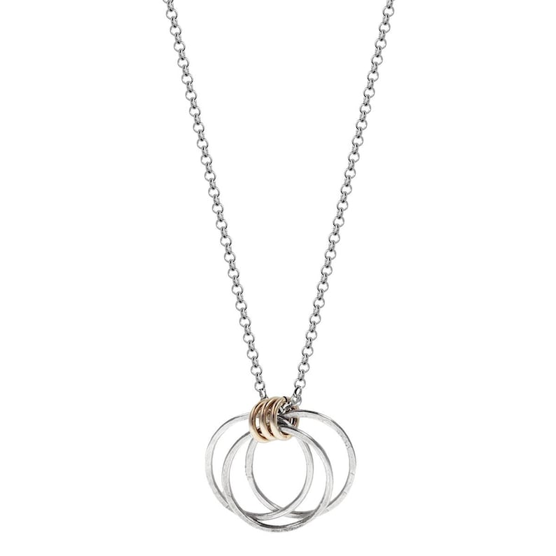 K&ouml;nnte beinhalten: Silberfarbene Halskette mit einem Anh&auml;nger aus drei ineinandergreifenden Kreisen und einem goldfarbenen Ring. Die Kette ist im filigranen Glieder-Stil gehalten, und der Anh&auml;nger ist mittig platziert. Die Halskette ist f&uuml;r den t&auml;glichen Gebrauch konzipiert.
