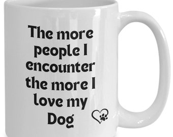 May include: White ceramic coffee mug with black text that reads "The more people I encounter the more I love my Dog" with a heart and paw print.