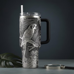 May include: A matte black stainless steel tumbler with a handle and a clear lid featuring a white straw. The exterior is decorated with a detailed white line art illustration of a parrot perched on a branch surrounded by tropical foliage.