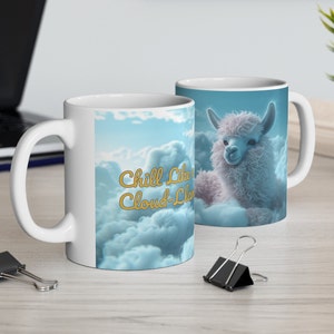 May include: White ceramic mug with a fluffy white llama sitting on clouds. The mug has the text "Chill Like a Cloud-Llama" in gold lettering.