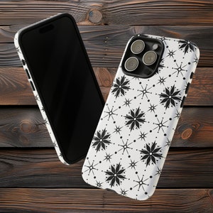 May include: A white phone case with a black and white geometric pattern. The case has a cutout for the camera lens.