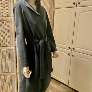 May include: A dark blue, long-sleeved, belted coat with a collar.