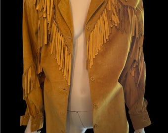 May include: Mustard-colored suede jacket with fringe detailing on the shoulders and sleeves. The jacket has a button-up front and a classic collar. The fringe adds a unique, vintage flair to the garment.