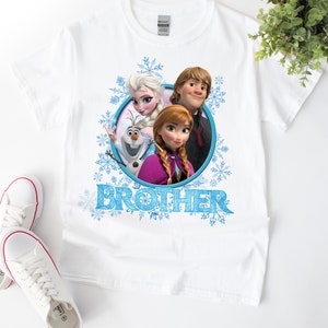 May include: White t-shirt with a blue, white, and pink graphic of Elsa, Anna, and Olaf from the movie Frozen. The graphic is in a circle with the word "BROTHER" below it.
