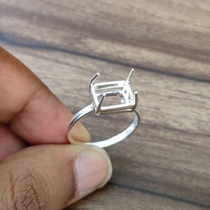 Op de afbeelding: Zilveren ring met een rechthoekige zetting voor een edelsteen. De zetting is ontworpen om een rechthoekige of smaragd geslepen steen te houden.