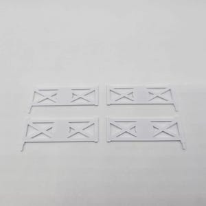 May include: Four white plastic fence sections with a criss-cross design. Each section is approximately 25 cm long.