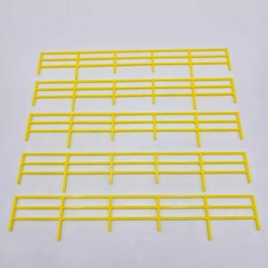 May include: Five yellow plastic fence sections, each with three horizontal rails. The sections are arranged in a stack, with the top section being the shortest and the bottom section being the longest.
