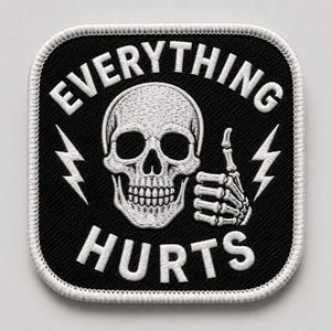 May include: Square black patch with white embroidered text and design. The text reads "EVERYTHING HURTS" with a skull and skeleton hand giving a thumbs up. Two white lightning bolts are on either side of the skull.