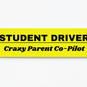 May include: Yellow and black warning sign with the text "STUDENT DRIVER Crazy Parent Co-Pilot".