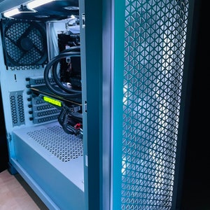 May include: A white computer case with a teal blue front panel. The front panel has a mesh design with a white light shining through it. The case is open and the inside of the computer is visible.