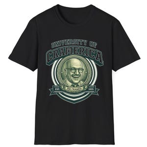 May include: Black t-shirt featuring a graphic of Jim Cramer with the text "UNIVERSITY OF CRAMERICA" in green and white. The design includes the text "EST. 1955" and "JIM CRAMER". The shirt is a crew neck.