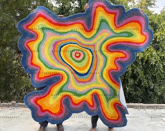 May include: A large, colorful rug with a swirling, abstract design. The rug is made of a soft, plush material and features a variety of colors, including blue, green, yellow, orange, red, and pink.