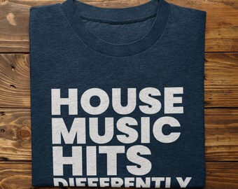 May include: A navy blue t-shirt with white text that reads "HOUSE MUSIC HITS DIFFERENTLY".