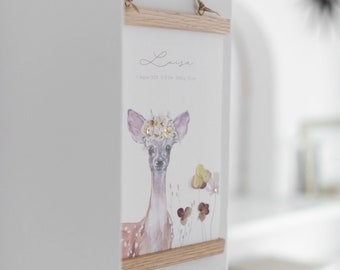 Könnte beinhalten: Ein weißer gerahmter Druck mit einer Aquarell-Illustration eines Rehs mit einer Blumenkrone. Der Druck trägt den Namen "Louisa" und das Datum "1. August 2021, 12:31 lb, 380 g, 51 cm" unter der Illustration.