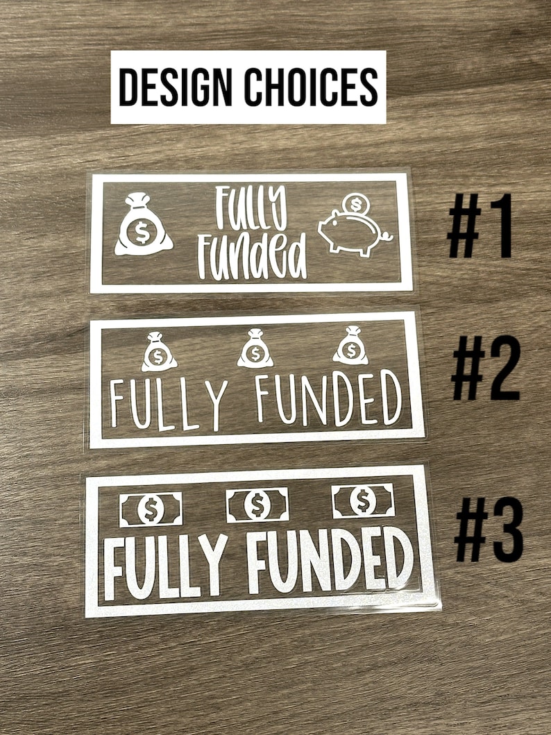 Puede incluir: Tres calcoman&iacute;as rectangulares de vinilo blanco etiquetadas #1, #2 y #3, cada una con el texto "FULLY FUNDED" en diferentes fuentes. El dise&ntilde;o #1 incluye un icono de bolsa de dinero y alcanc&iacute;a. El #2 tiene tres bolsas de dinero y el #3 tres billetes.