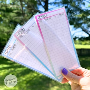May include: Three pastel-colored expense trackers with a grid layout. Each tracker has a section for category, date, description, +/- and balance. The trackers are labeled "Expense Trackers" and "Creating Staci".