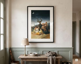 May include: A framed art print of Francisco Goya's The Witches' Sabbath, featuring a central horned goat figure surrounded by a group of seated people under a crescent moon in a dark, atmospheric landscape with muted earth tones.