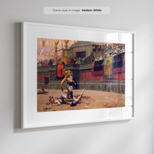 May include: A framed print depicting a historical scene of gladiators in an arena. The artwork features a gladiator in gold armor standing over a fallen opponent. The background shows a crowd in a stadium setting, with banners and architectural details.