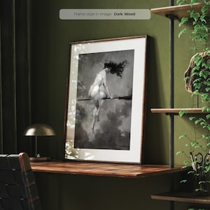 Puede incluir: Una ilustración en blanco y negro de una mujer montando una escoba en las nubes. La ilustración está enmarcada en un marco de madera oscura.