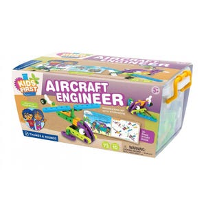 May include: A Kids First Aircraft Engineer kit with a storybook. The box features a colorful design with the words "Aircraft Engineer" and illustrations of airplanes. The kit includes building components in green, purple, and blue.