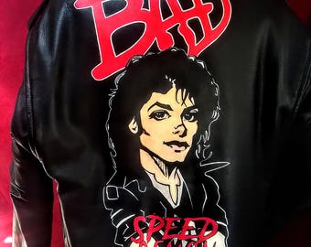 May include: Black leather jacket with a red "BAD" graphic and a cartoon illustration of a person with the text "SPEED DEMON" below.