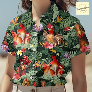 Puede incluir: Una camisa negra de botones con estampado tropical con gallos y exuberante follaje verde. La camisa tiene manga corta y cuello.