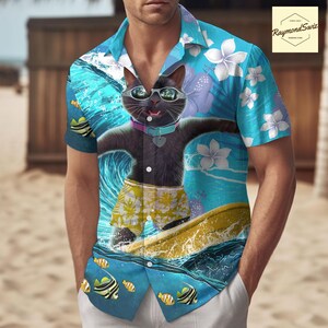 Puede incluir: Una camisa hawaiana azul y blanca con un gato negro que lleva gafas de sol y surfa sobre una ola. El gato lleva un bañador amarillo con estampado floral. La camisa tiene un estampado floral y diseños de peces.