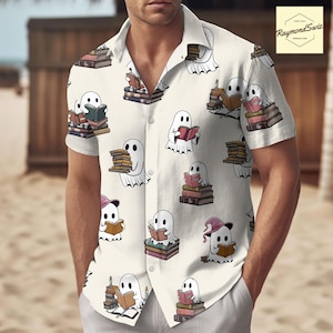 Puede incluir: Una camisa blanca de botones con un patrón de fantasmas leyendo libros. Los fantasmas son blancos y tienen un diseño simple y de dibujos animados. Los libros están apilados y tienen una variedad de colores y diseños.