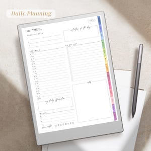 Puede incluir: Un planificador digital con una pantalla blanca, que presenta un horario diario, una lista de tareas y espacio para notas. El planificador tiene pesta&ntilde;as de colores para cada mes e incluye el texto "Daily Planning". Un l&aacute;piz &oacute;ptico gris descansa a su lado.