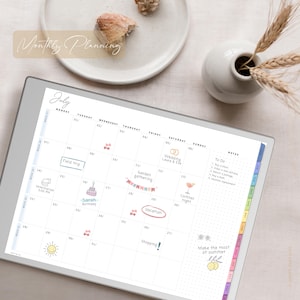 May include: A digital planner showing the month of July with event stickers. The planner has a to-do list and notes section. The words "Monthly Planning" are at the top. A white vase with wheat stalks is in the background.