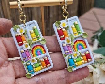 Regenboogboekoorbellen: handgemaakte boekenplankhanger van klei